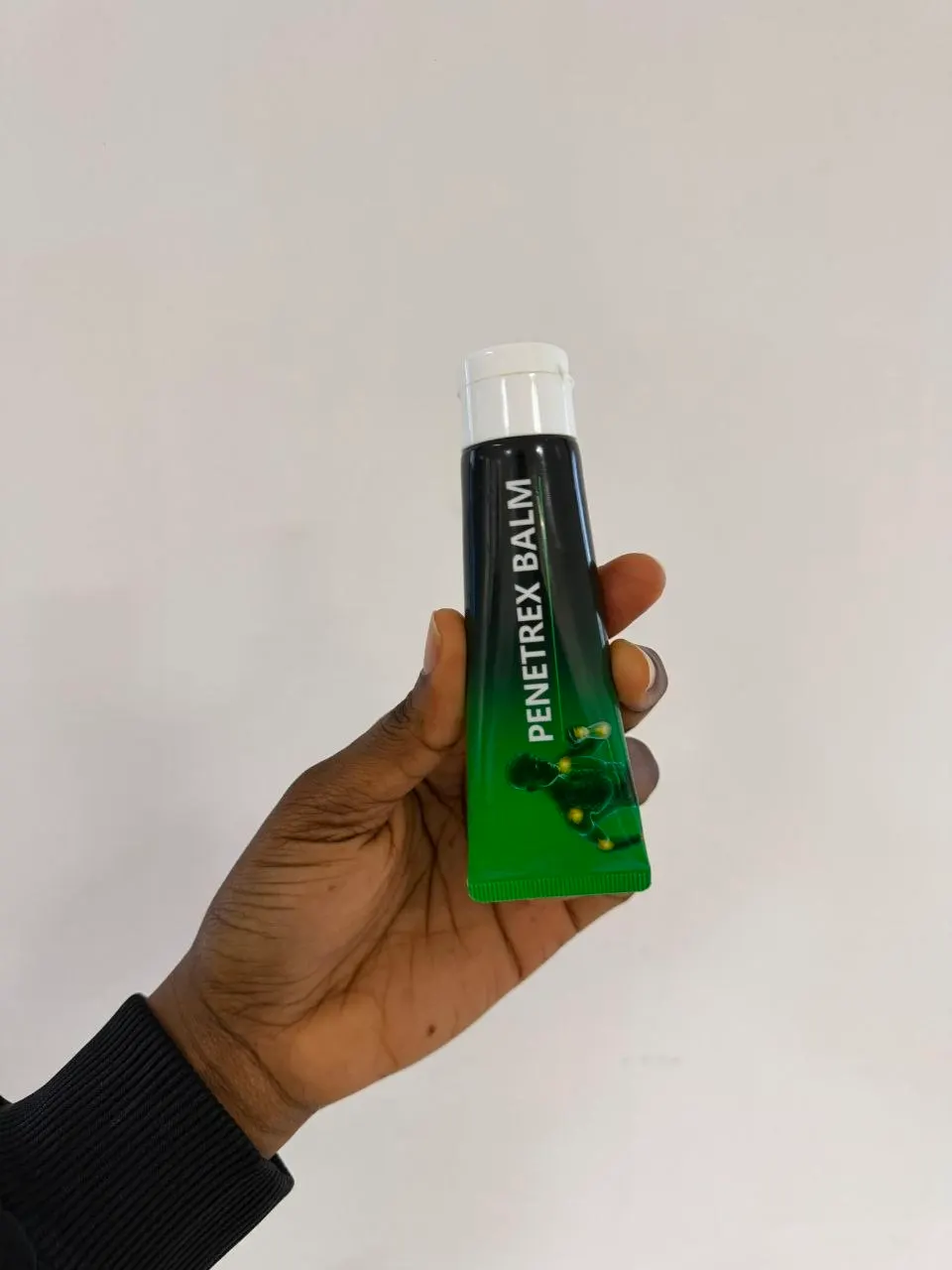 Hand holding the Penetrex Balm tube